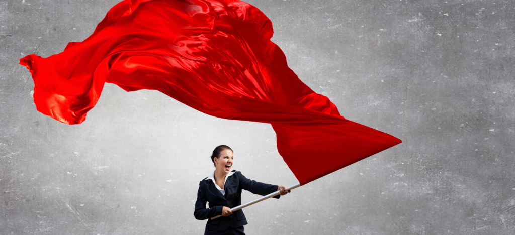 Woman in black business suit waving a large red flag